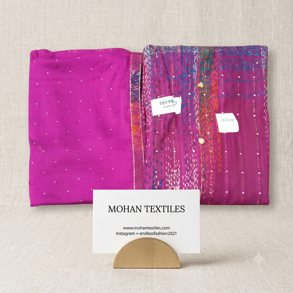 Folded magenta pink Kantha stitch pattern unstitched suit material with gold buttons and micro-dotted dupatta on beige background