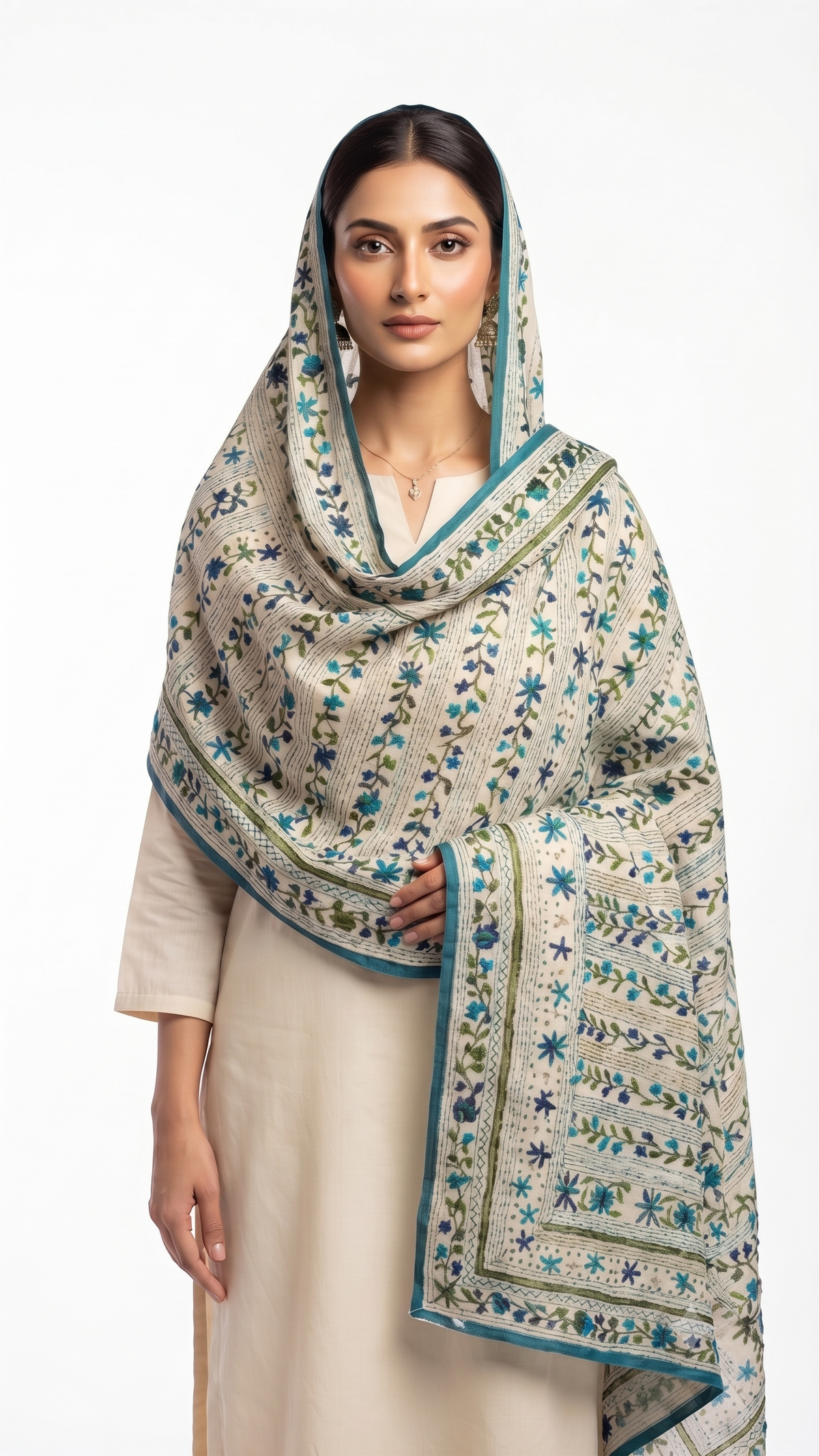 A woman modeling a beige and white printed dupatta with blue and green floral patterns and borders, paired with a cream-colored kurta against a plain white studio background.
