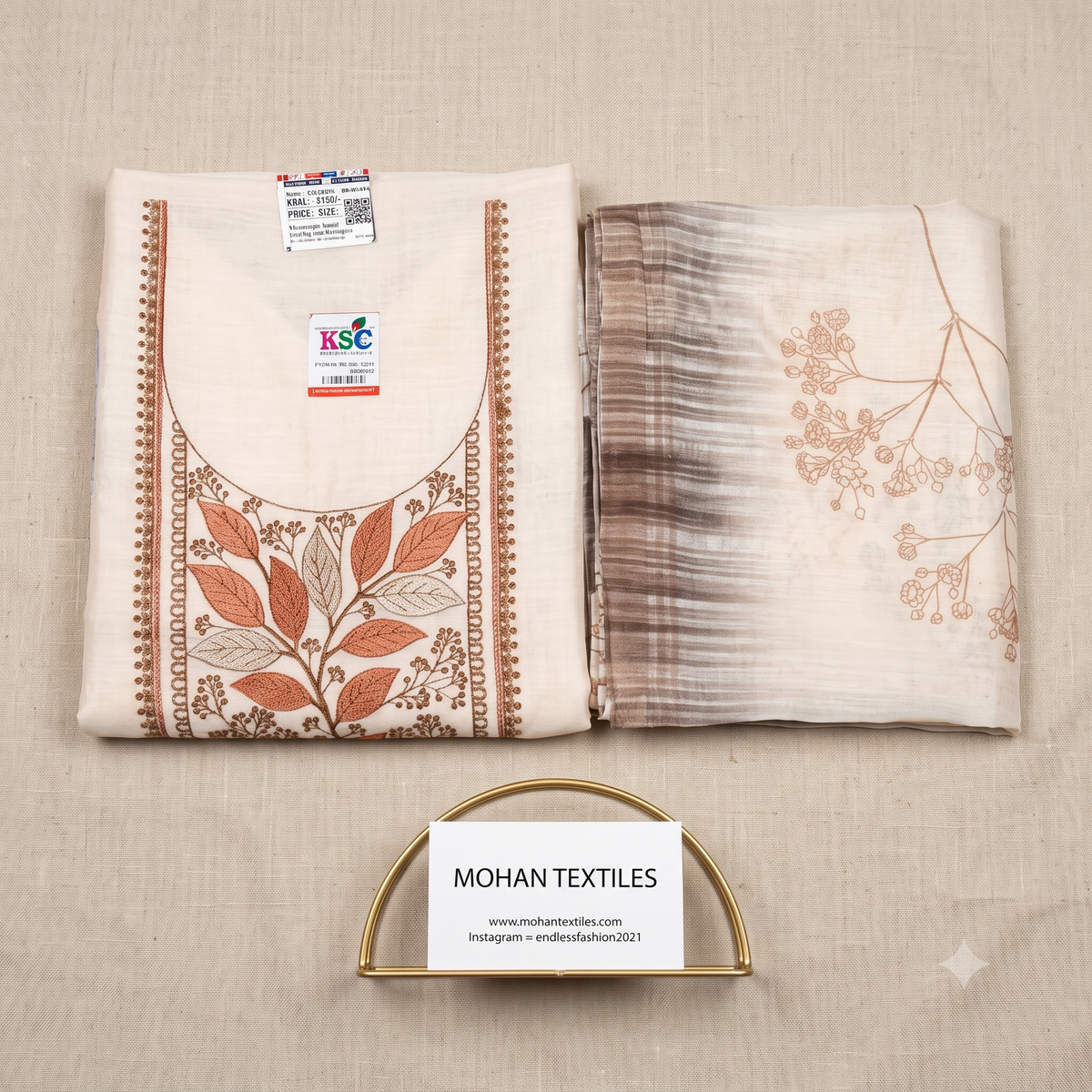 Detailed flat lay of an off-white linen unstitched suit kurta, showcasing intricate terracotta and rust color thread embroidery around the neckline, with a folded printed dupatta, from Mohan Textiles.